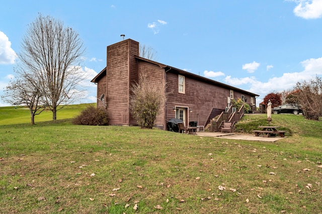 view of property exterior with a yard and a patio