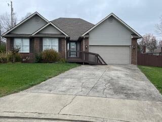 single story home with a front yard and a garage