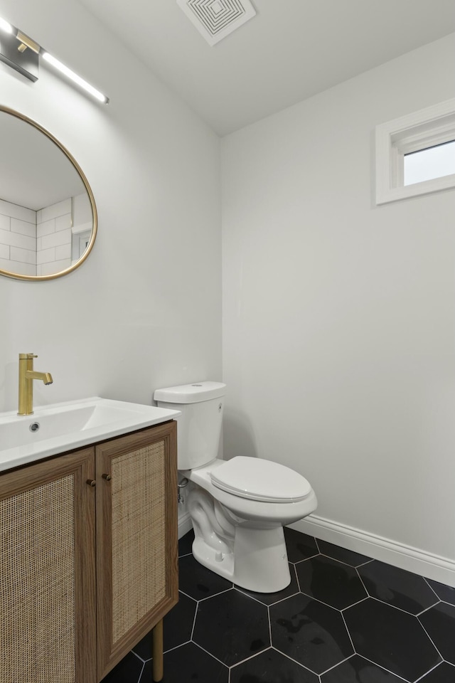 bathroom featuring tile patterned floors, vanity, and toilet