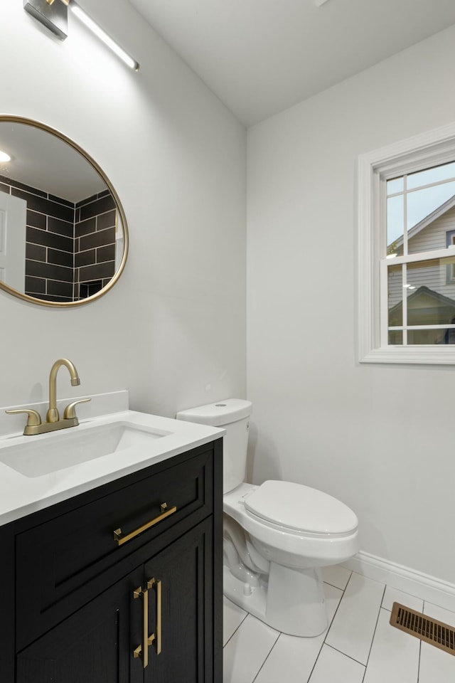 bathroom with tile patterned flooring, vanity, and toilet