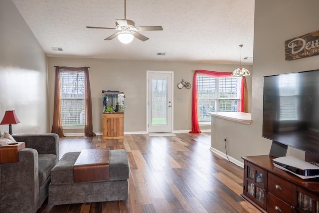 living room with a wealth of natural light, hardwood / wood-style floors, ceiling fan, and a textured ceiling