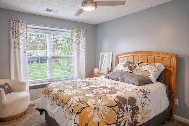 bedroom featuring ceiling fan, carpet, and a textured ceiling