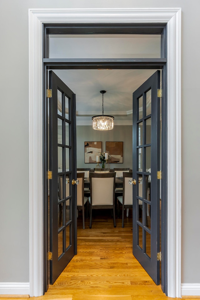 office space with crown molding, french doors, wood-type flooring, and a notable chandelier