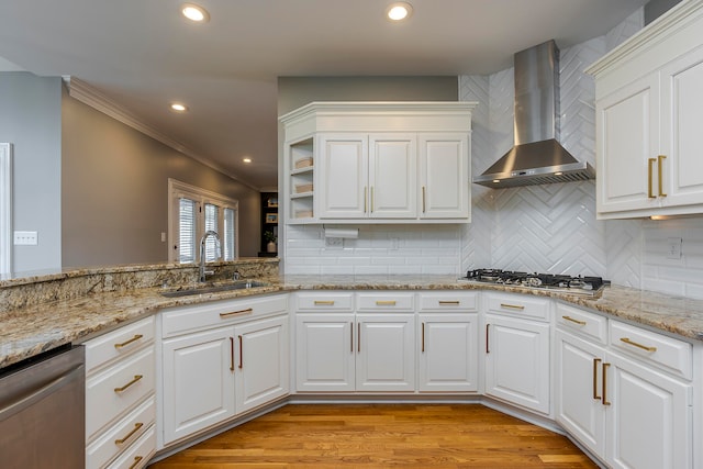 kitchen with sink, wall chimney exhaust hood, stainless steel appliances, light hardwood / wood-style flooring, and white cabinets