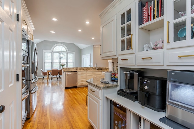 kitchen with light wood-type flooring, white cabinetry, and appliances with stainless steel finishes