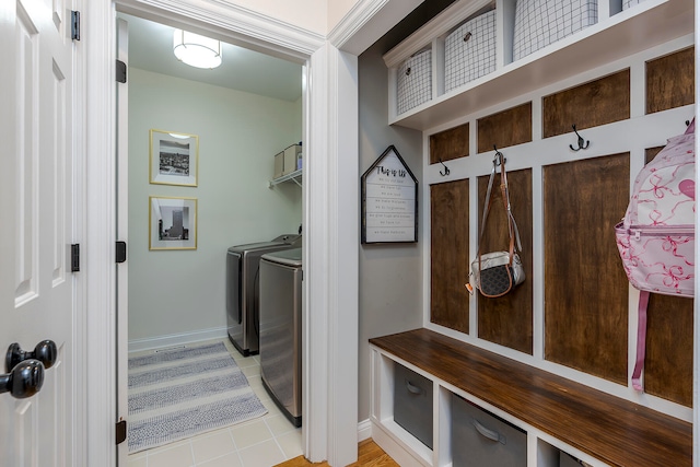 mudroom featuring light tile patterned flooring and separate washer and dryer