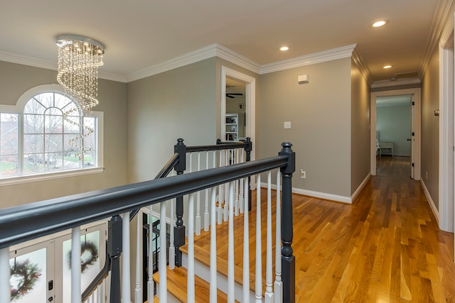 hallway with crown molding, a chandelier, and hardwood / wood-style flooring