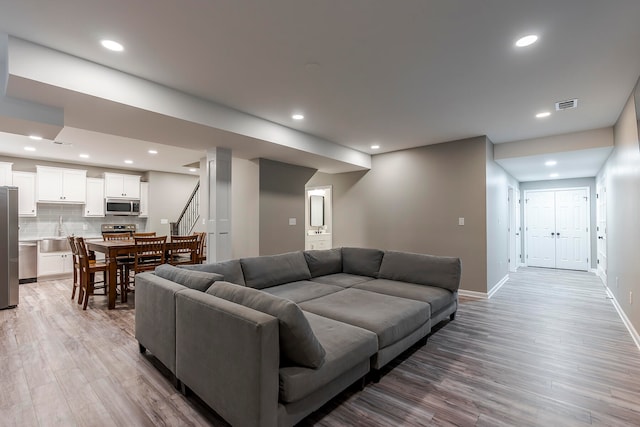 living room with sink and light hardwood / wood-style flooring