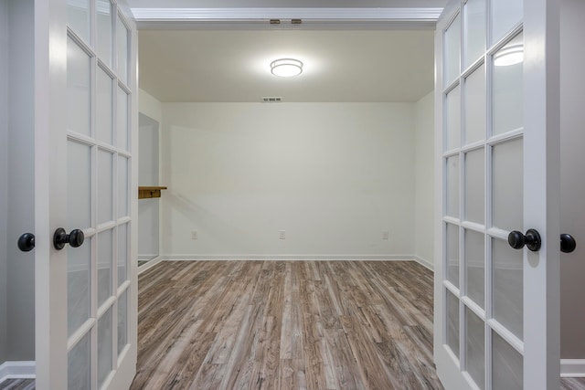 spare room featuring french doors and light wood-type flooring