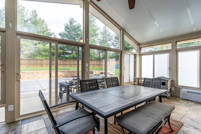 sunroom featuring a wall mounted air conditioner, ceiling fan, and vaulted ceiling