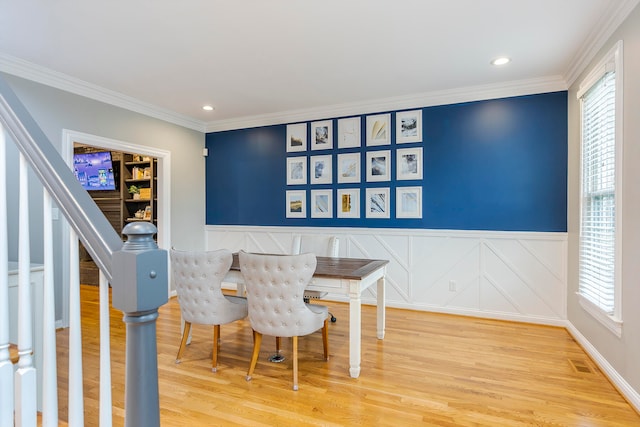 dining area with wood-type flooring, crown molding, and a wealth of natural light