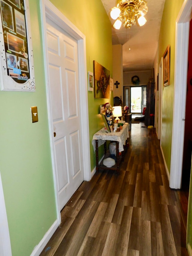 hall with a notable chandelier and dark hardwood / wood-style floors