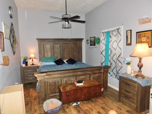 bedroom with vaulted ceiling, ceiling fan, a textured ceiling, and dark hardwood / wood-style floors