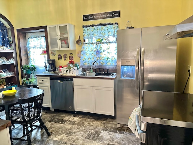 kitchen featuring white cabinets, appliances with stainless steel finishes, exhaust hood, and sink