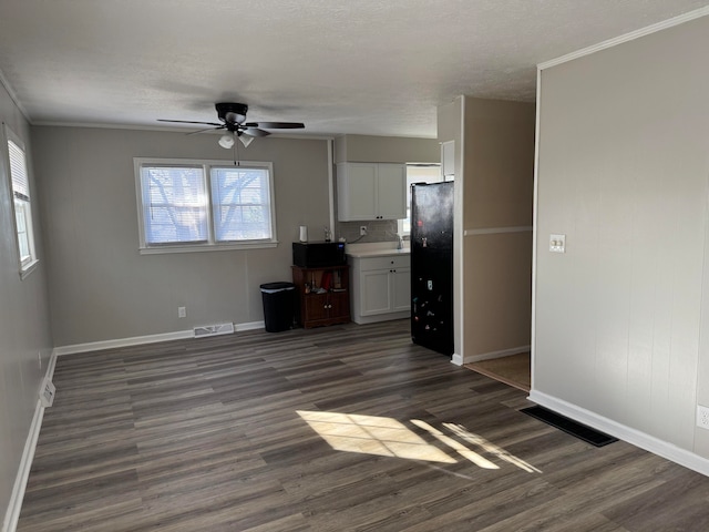 interior space with white cabinetry, crown molding, ceiling fan, and dark hardwood / wood-style floors