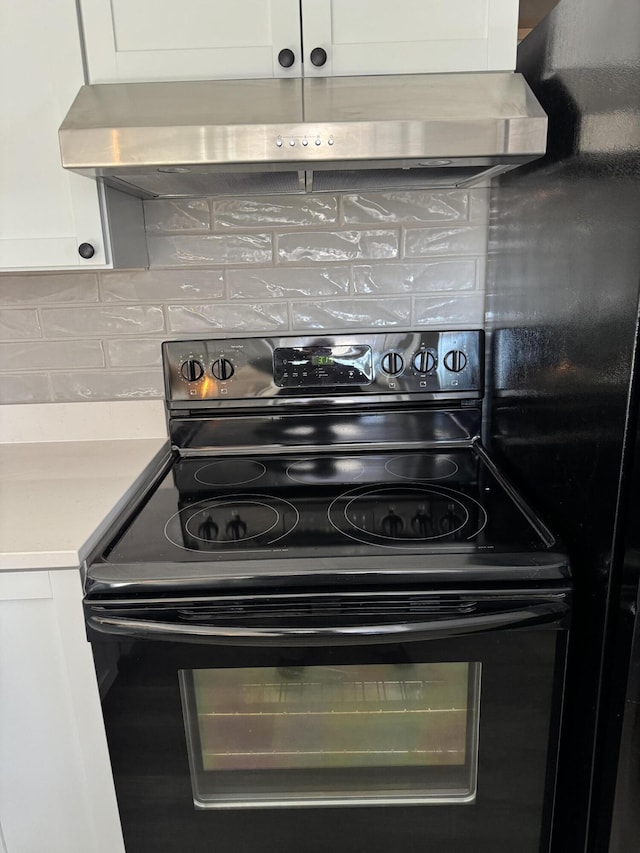 kitchen with backsplash, ventilation hood, black range with electric cooktop, light countertops, and white cabinetry