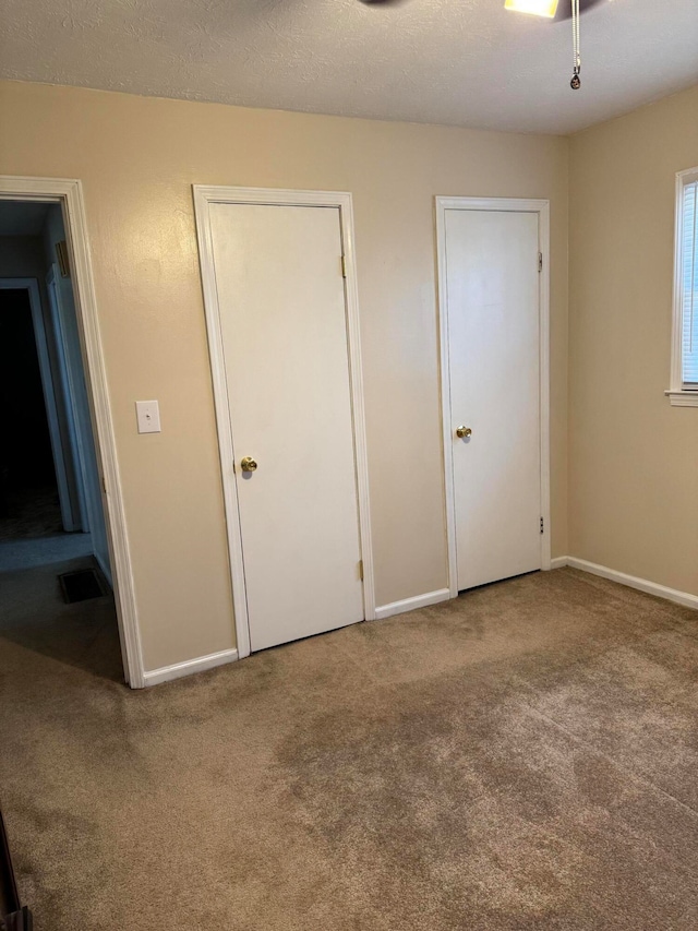 unfurnished bedroom with carpet and a textured ceiling