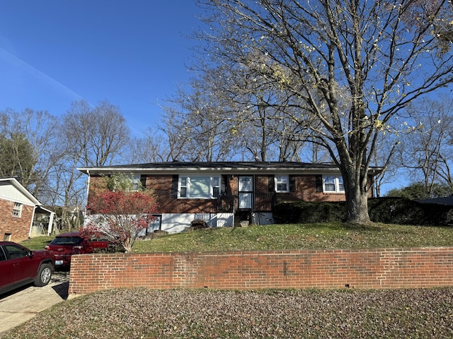 single story home featuring brick siding and a front lawn