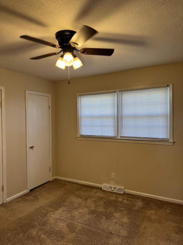 unfurnished room featuring carpet, visible vents, and baseboards