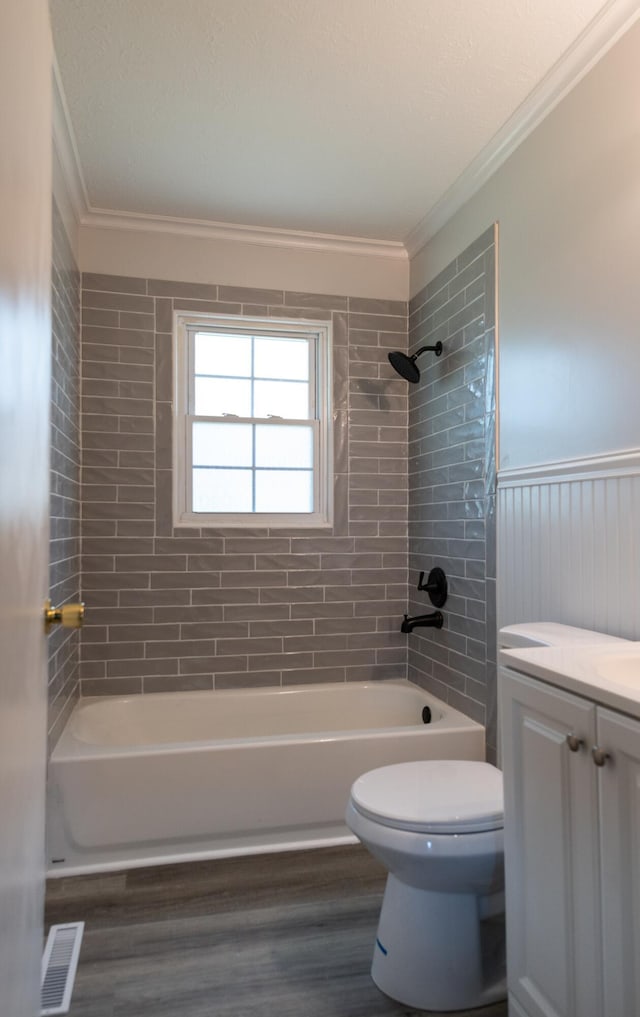 bathroom featuring visible vents, toilet, ornamental molding, shower / bathing tub combination, and wood finished floors