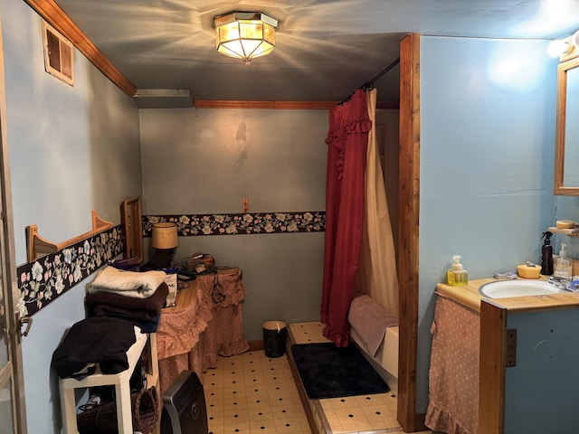 bedroom with tile patterned floors, visible vents, and a sink