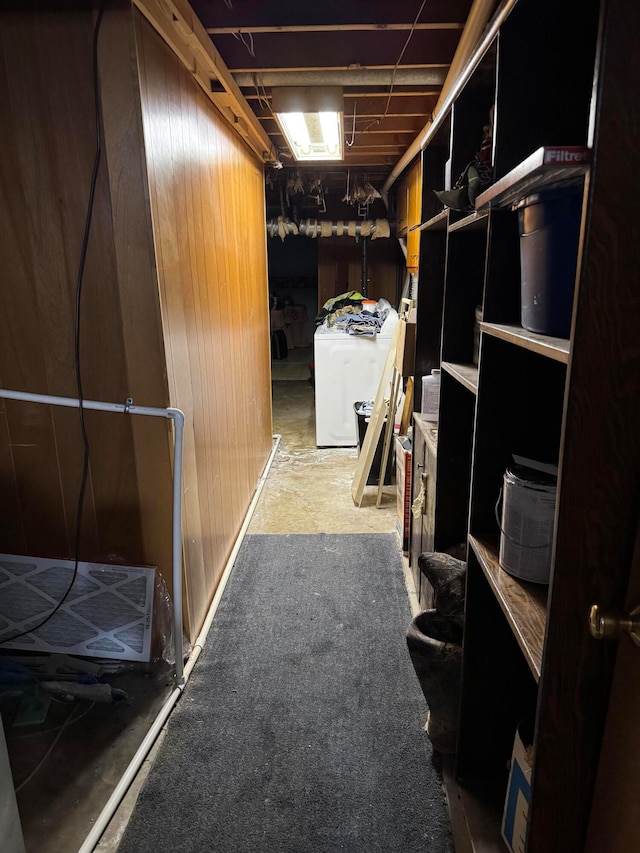 basement with wood walls and washer / dryer