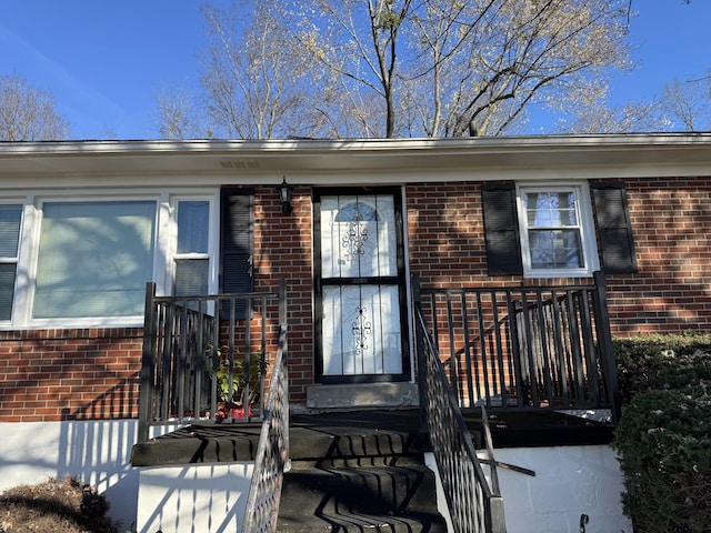 doorway to property featuring brick siding