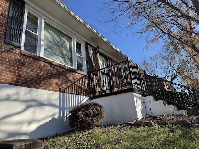 view of home's exterior with brick siding and stairs