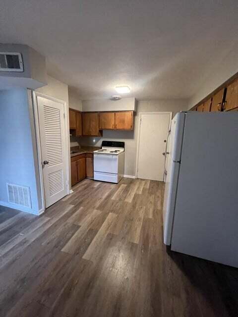 kitchen featuring hardwood / wood-style flooring and white appliances