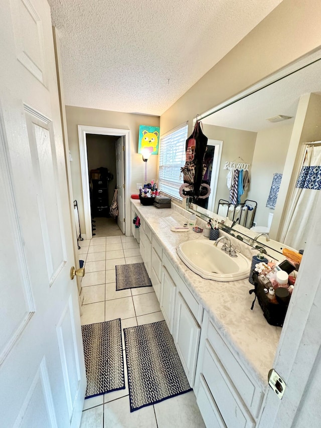 bathroom featuring tile patterned flooring, vanity, and a textured ceiling