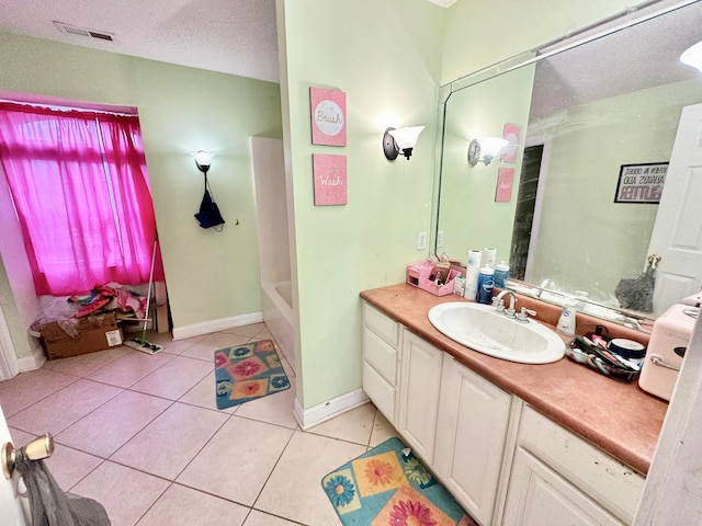 bathroom with vanity, a textured ceiling, and tile patterned flooring