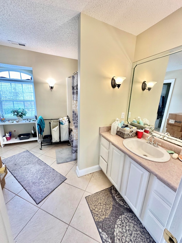 bathroom featuring tile patterned floors, vanity, and a textured ceiling