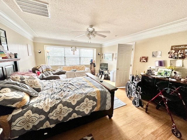 bedroom featuring a textured ceiling, light hardwood / wood-style flooring, ceiling fan, and ornamental molding