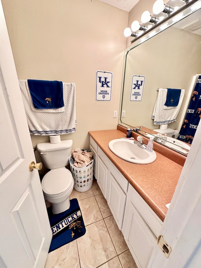 bathroom featuring tile patterned flooring, vanity, and toilet