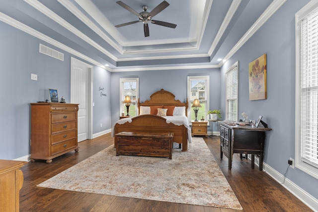 bedroom with a tray ceiling, dark hardwood / wood-style flooring, and ornamental molding