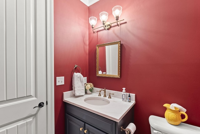 bathroom featuring vanity, toilet, and ornamental molding