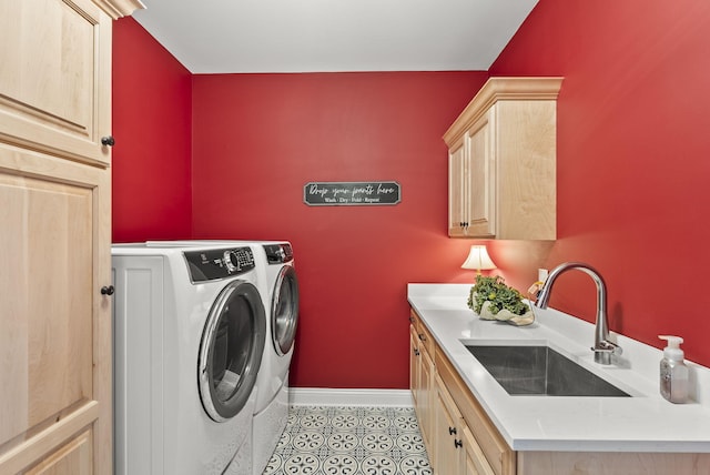 washroom with washing machine and dryer, sink, light tile patterned floors, and cabinets