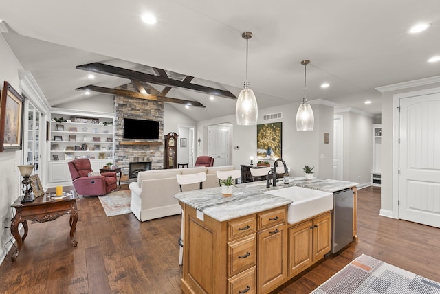 kitchen featuring vaulted ceiling with beams, a kitchen island with sink, and stainless steel dishwasher