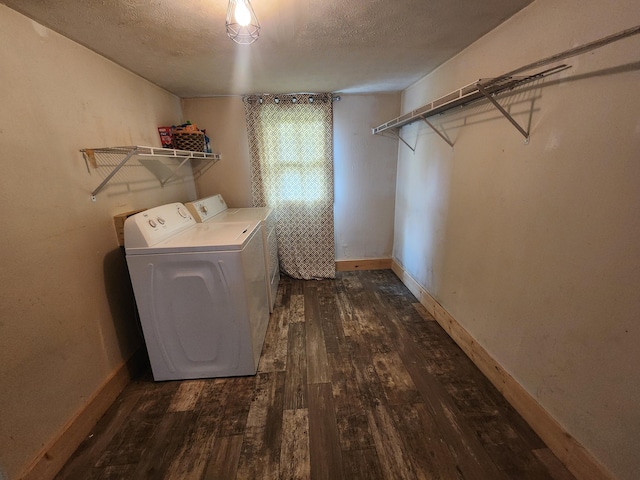 laundry area with a textured ceiling, washer and clothes dryer, and dark hardwood / wood-style floors