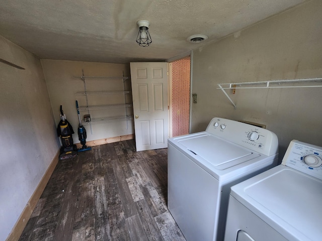 washroom featuring a textured ceiling, separate washer and dryer, and dark hardwood / wood-style floors