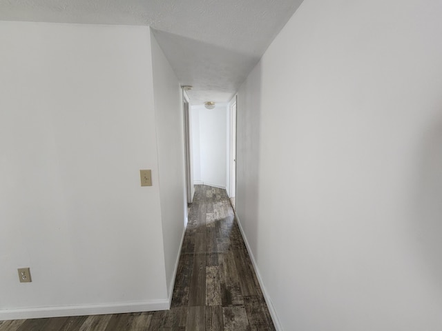 corridor featuring dark hardwood / wood-style floors and a textured ceiling