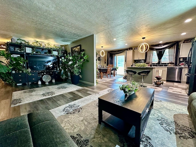 living room with hardwood / wood-style flooring, a textured ceiling, and a chandelier