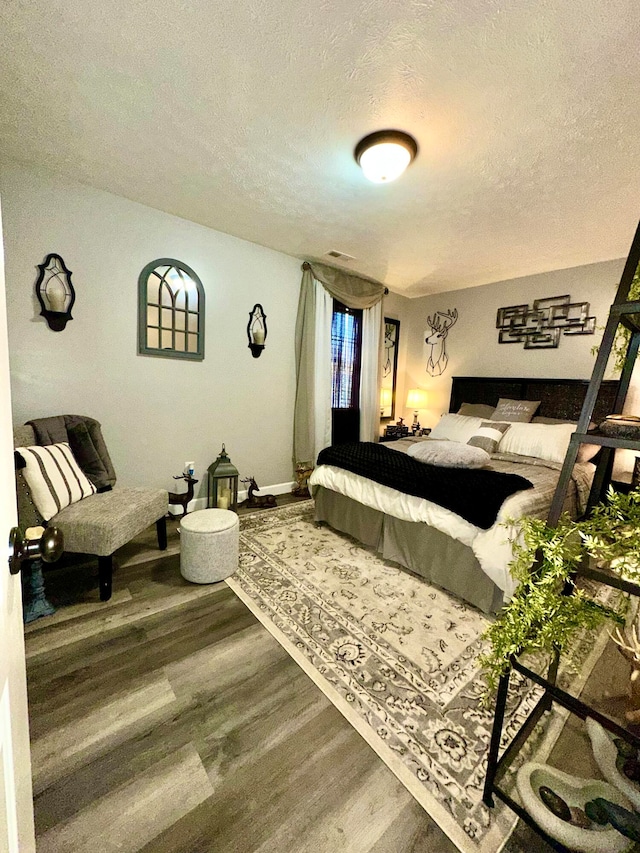 bedroom featuring hardwood / wood-style floors and a textured ceiling