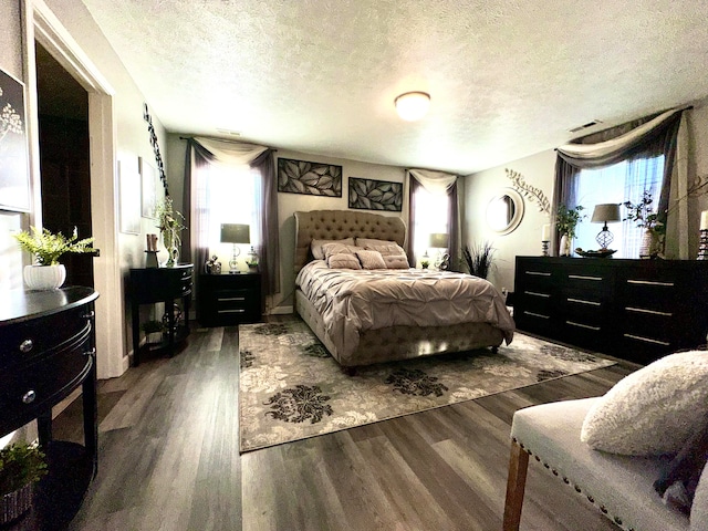 bedroom with a textured ceiling and dark wood-type flooring