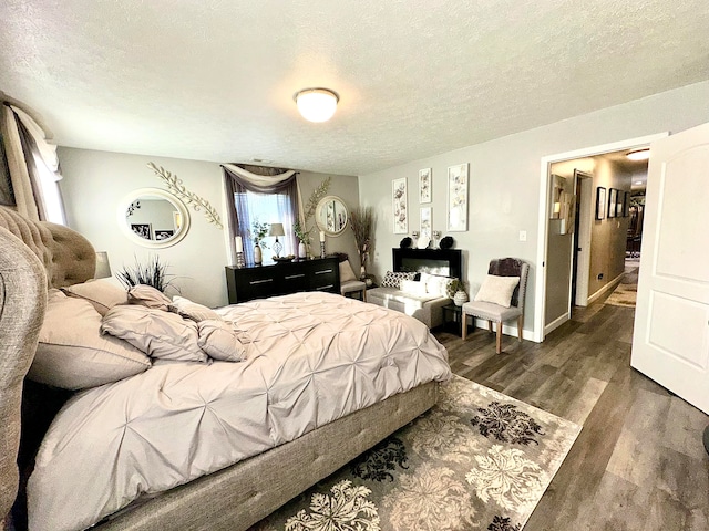 bedroom featuring a textured ceiling and dark hardwood / wood-style floors