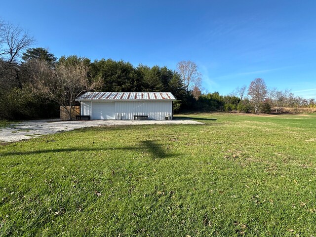 view of yard with a garage and an outbuilding