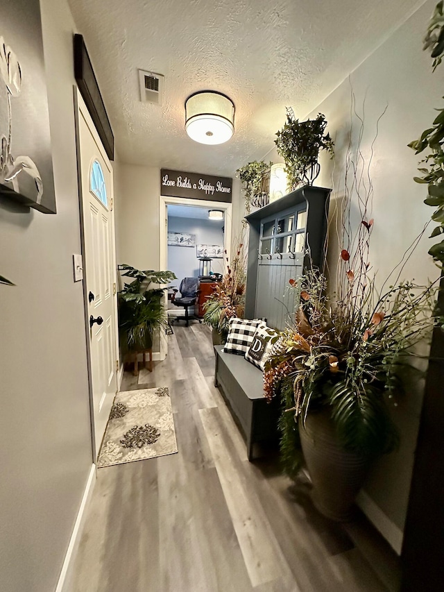 hallway with wood-type flooring and a textured ceiling