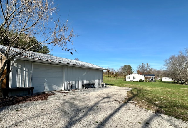 view of side of home with a lawn, an outdoor structure, and a garage