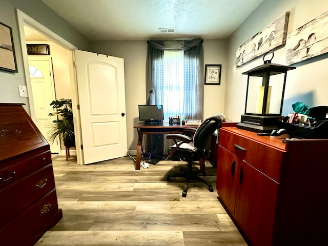 office with a textured ceiling and light hardwood / wood-style flooring