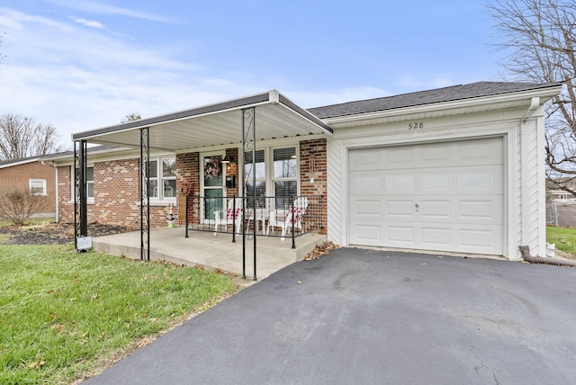 ranch-style house featuring a porch, a garage, and a front lawn